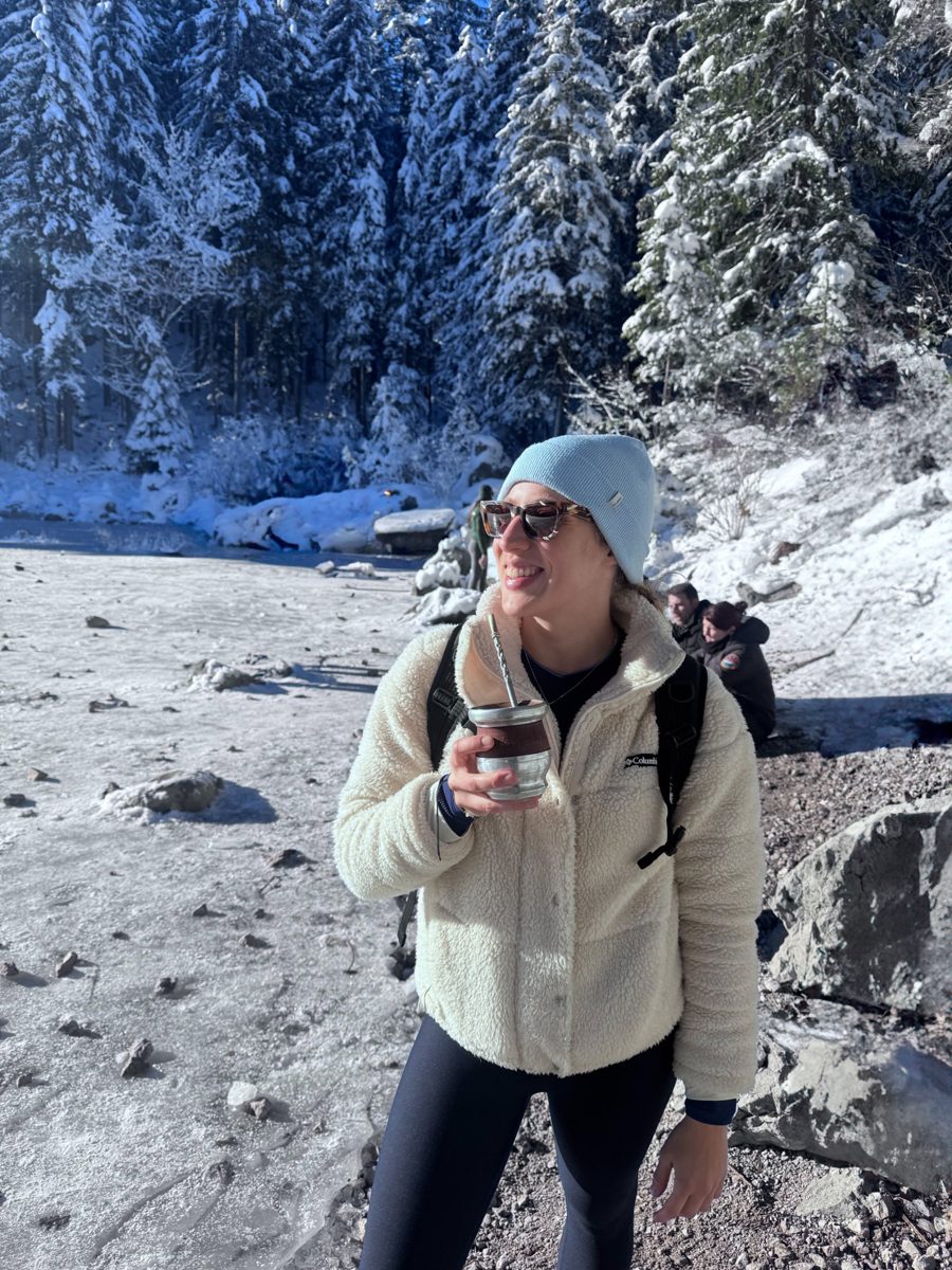 Daniela Moirano on a winter hike in the snow, holding a cup of mate